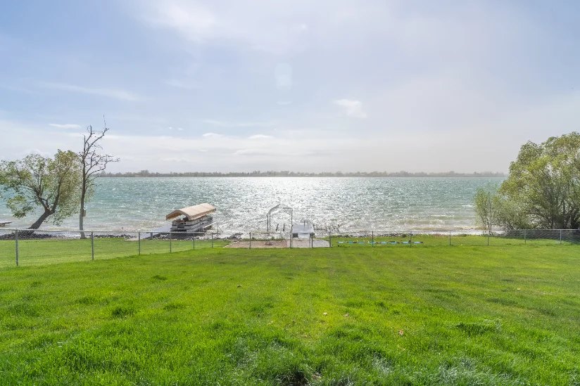 The backyard lawn running down to the water